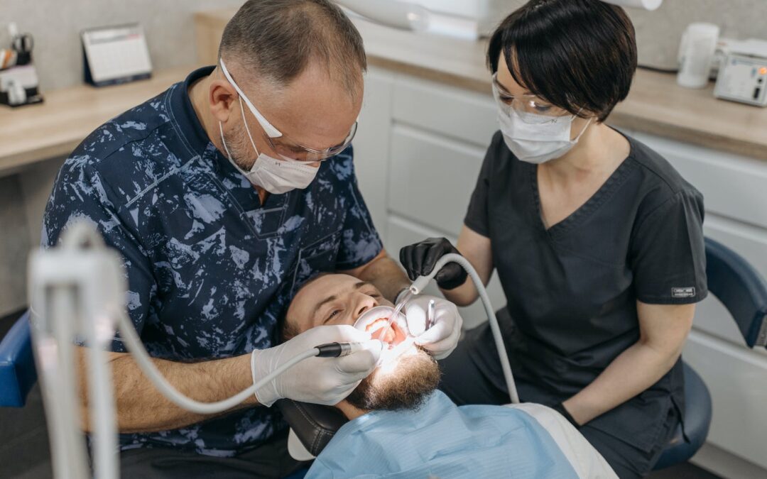 A Dentist and His Dental Assistant Working on a Patient