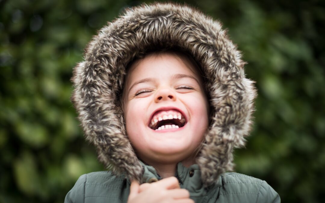 selective focus photography of child laughing